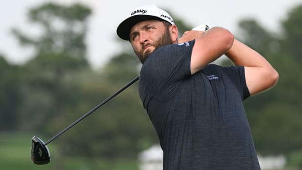Jon Rahm follows through on a swing with his driver